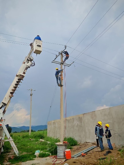 Personal de GE Solutions trabajando en una línea eléctrica aérea con apoyo de una grúa
