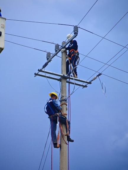 Técnicos instalando líneas eléctricas aéreas